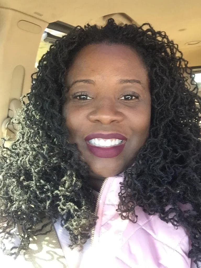 Long curly locs car selfie in pink jacket