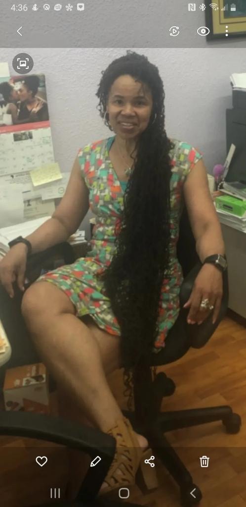 Waist-length locs seated in office chair