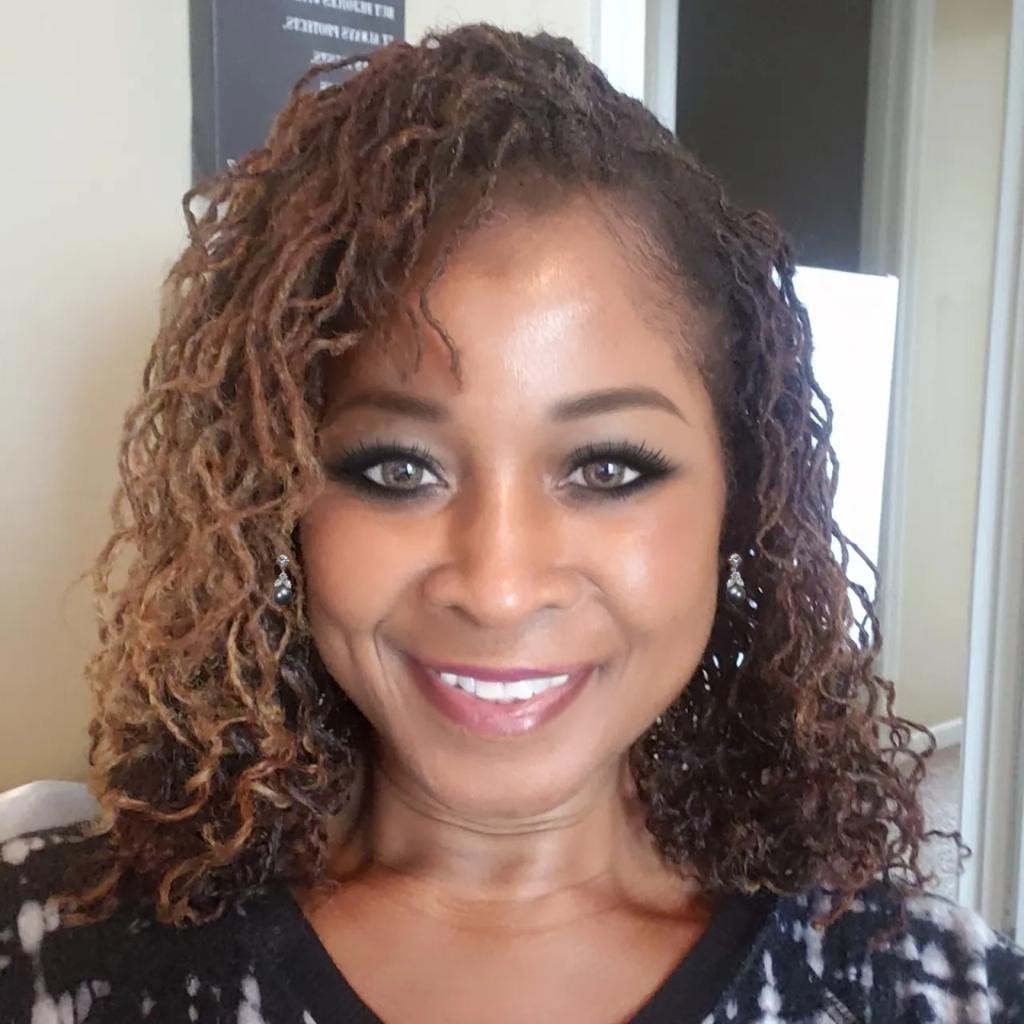 Curly brown locs with diamond earrings smiling portrait