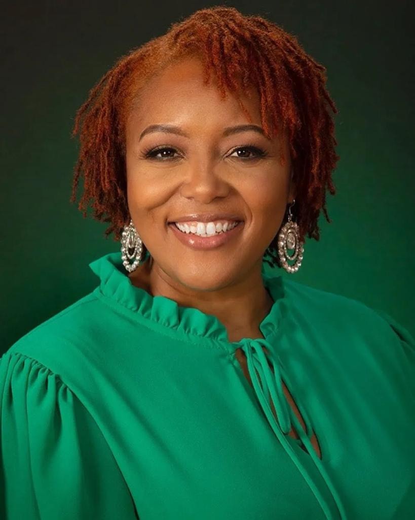 Short auburn locs in green top professional portrait